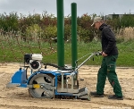 Die Sandreinigungsmaschine gräbt sich 20 cm tief in den Sand und holt alles heraus, was nicht im Fallschutzsand sein darf